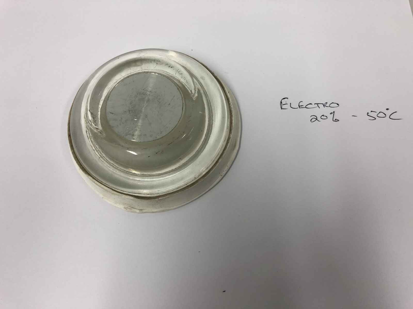 Lens photographed beside its handwritten process card