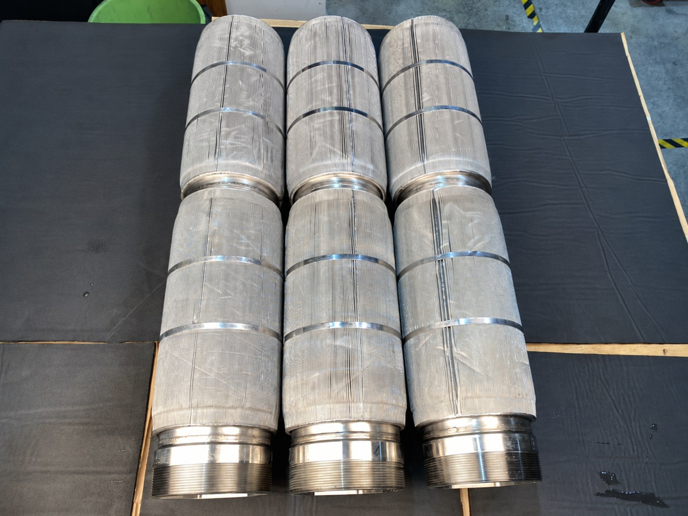 The same three elements cleaned and laid out full length, mesh open and the machined collars bright