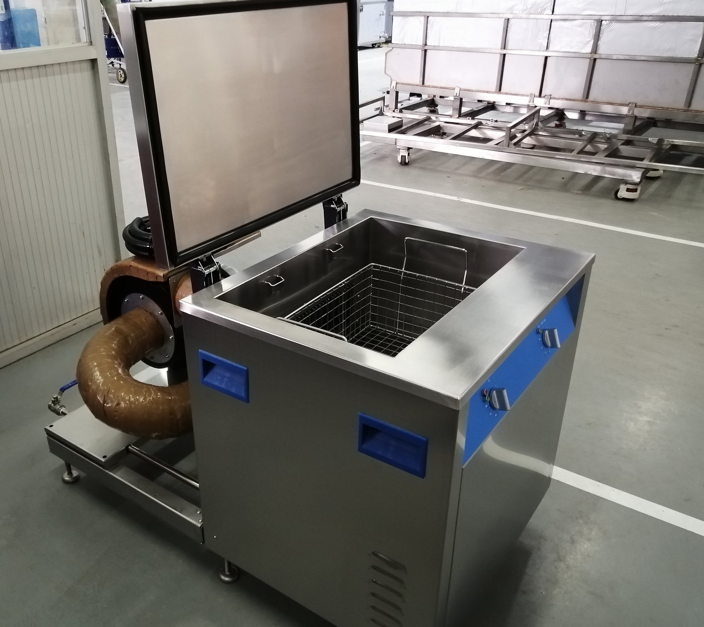 A Misonics hot air drying tank on the factory floor, cover raised, insulated hot air ducting and blower mounted on the side