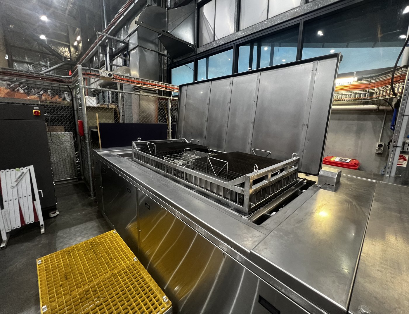 EvoSonic elevator platform raised with loaded baskets draining over the bath