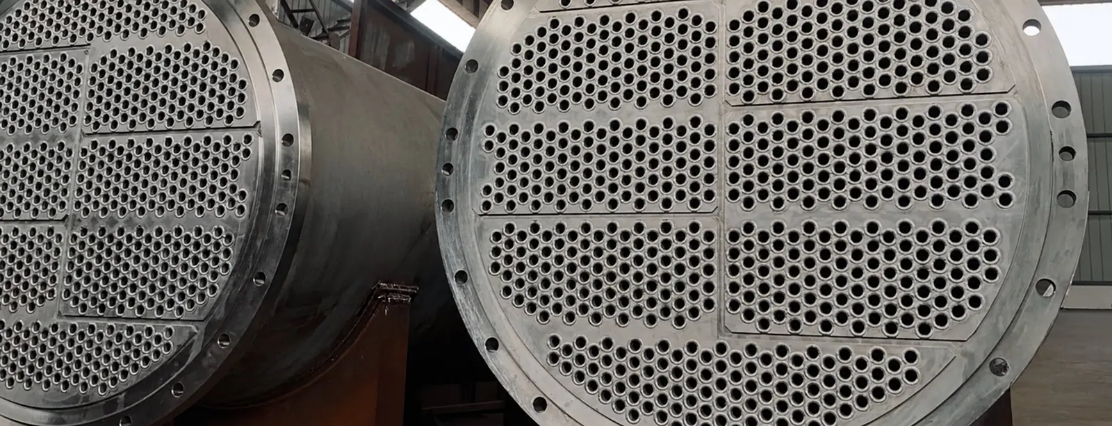 Two shell-and-tube heat exchanger bundles on a workshop floor