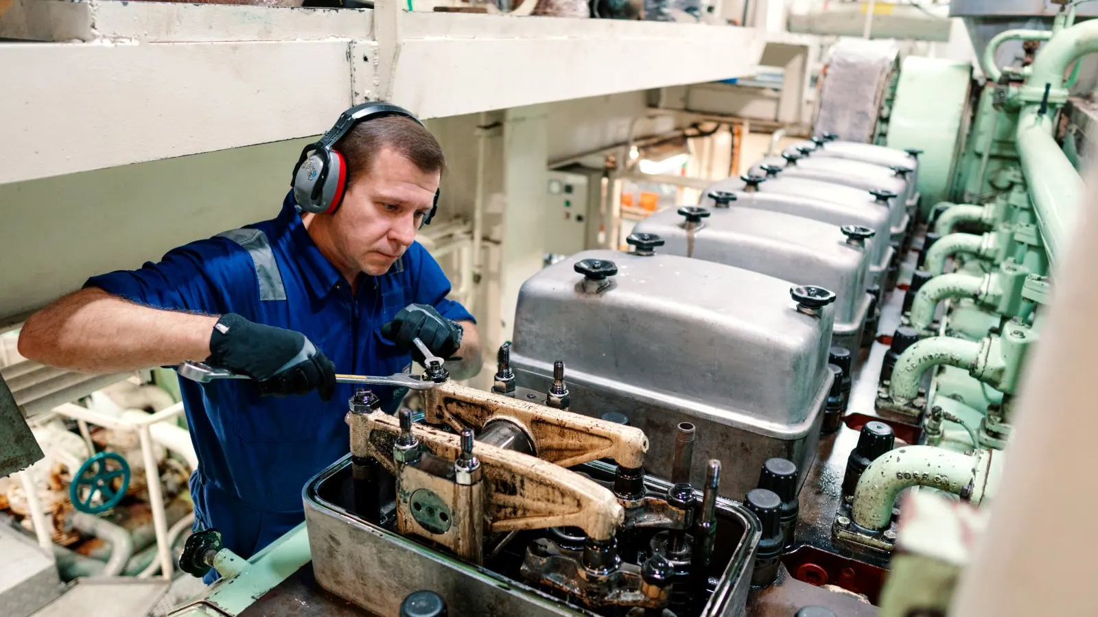 Engineer overhauling a marine diesel below decks, the parts that go to marine ultrasonic cleaning