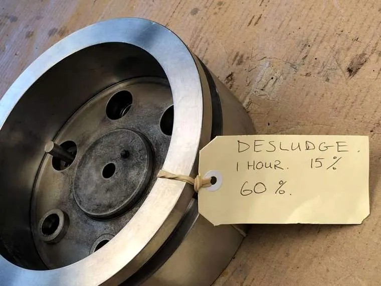 Die with a handwritten trial tag recording a one hour desludge cycle
