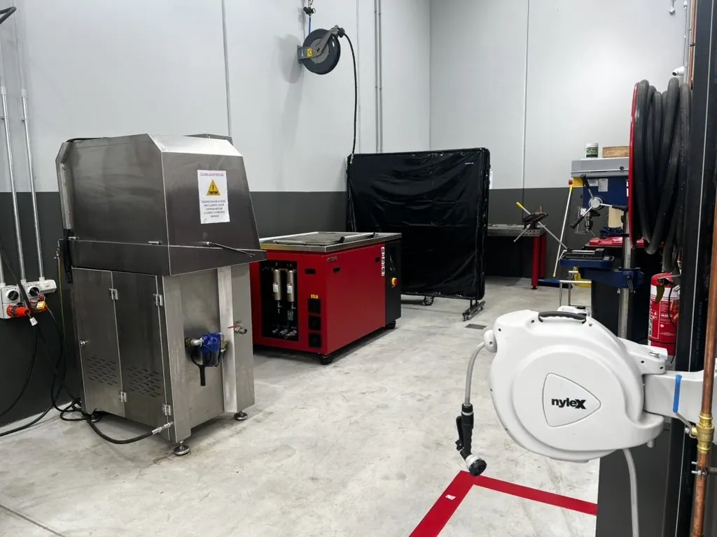Misonics MSX 240 ultrasonic tank working beside a stainless spray parts washer in a workshop